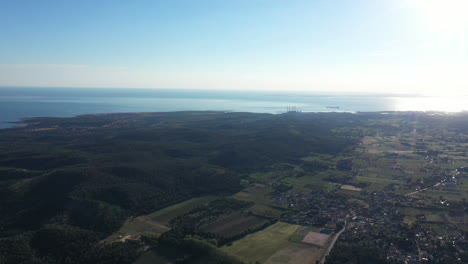 Large-aerial-view-of-a-rural-landscape-with-fields-forest-and-mediterranean-sea